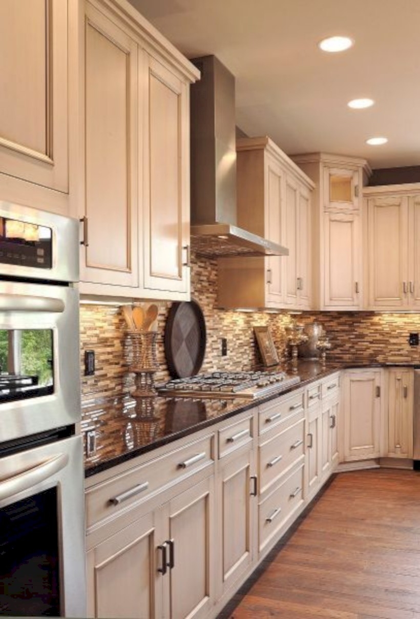 Beautiful creamy white kitchen cabinets with stone tile backsplash