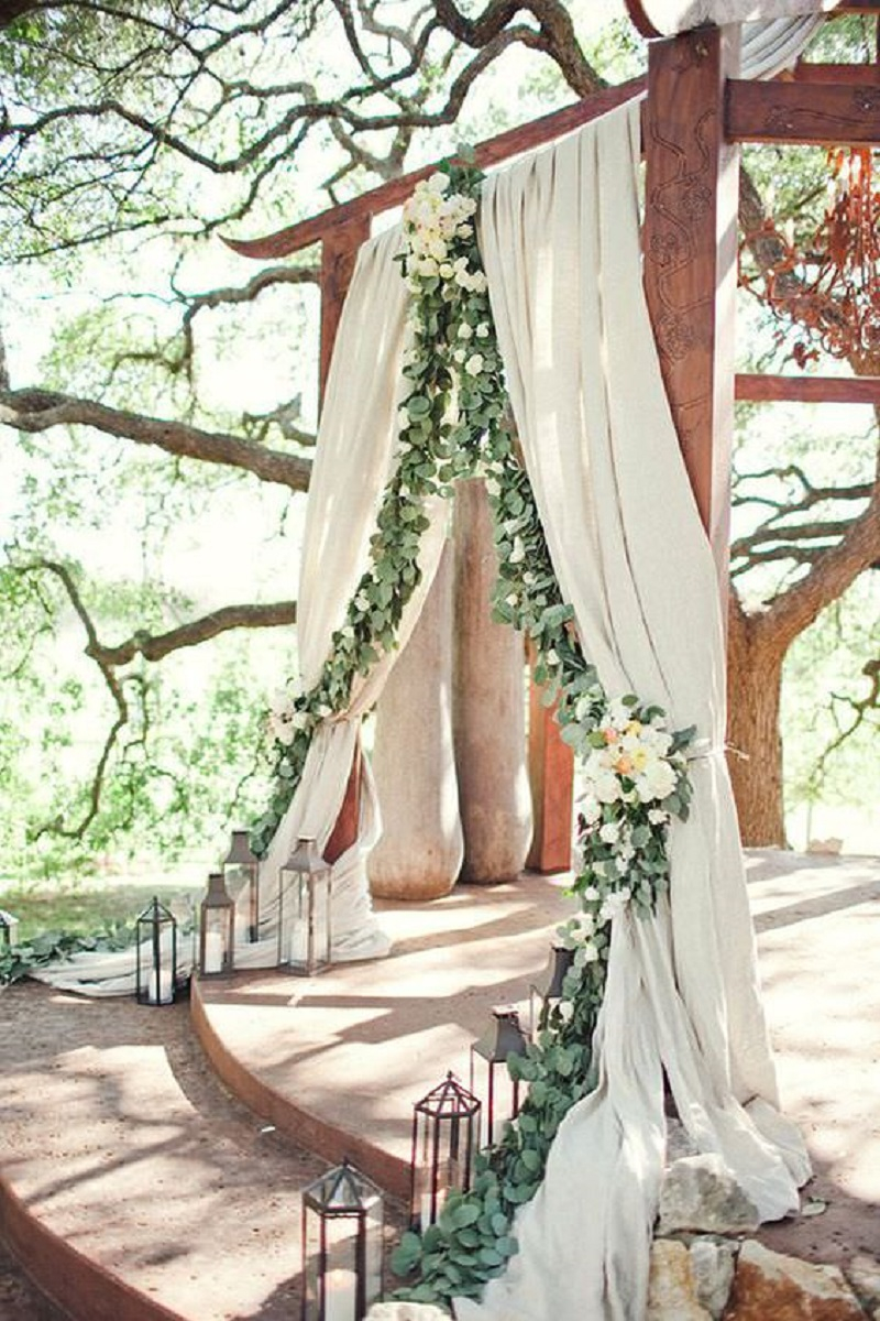 Decorated wood arch with long veils and floral composition
