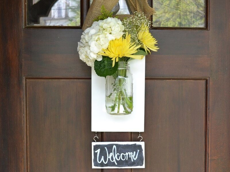 Mason jar flowers on a welcome sign
