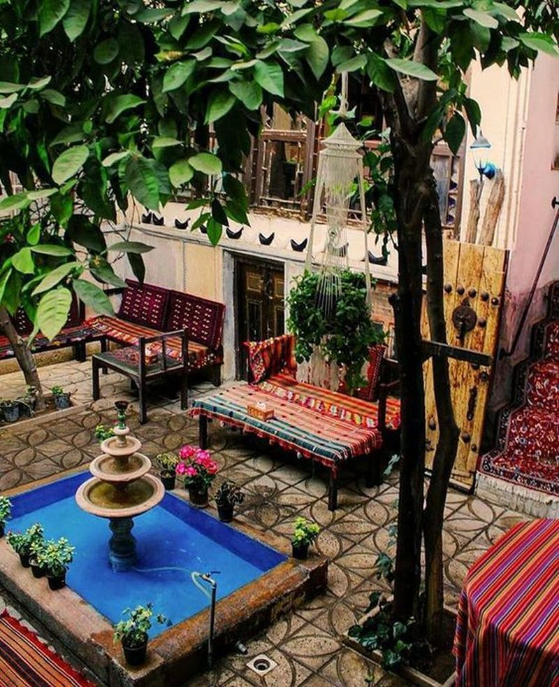 Beautiful boho exterior design with unique patterned chairs, white walls, a small pool, houseplants to perfect your home design