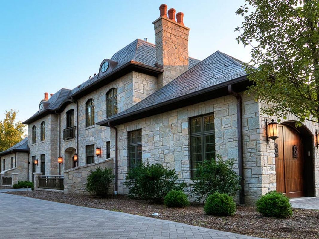 Classic exterior design with light grey stone walls, classic window, chimney and old wooden door to perfect your classic home