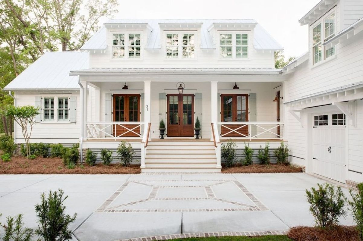 Modern farmhouse exterior with side garage, white walls, light grey tin roof, covered porch, rich brown wood doors