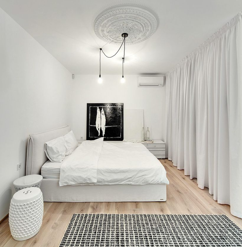 Simple white bedrooms with white beds, white blankets, large white curtains, white round chairs, wooden floors to make it more comfortable