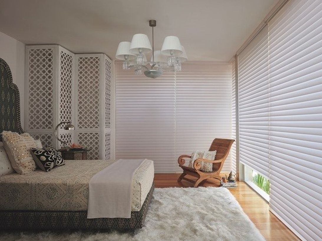 Stunning white bedrooms with white walls, white rectangular carpets, white blankets, large white curtains, wooden floors and chairs to create calm