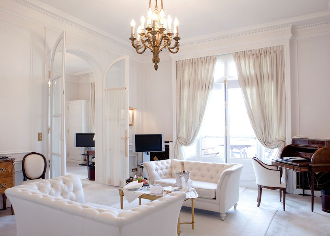 Wonderful traditional white living room from floor to ceiling. white curtains, white floor carpets, and white sofa sets to make you sleep better