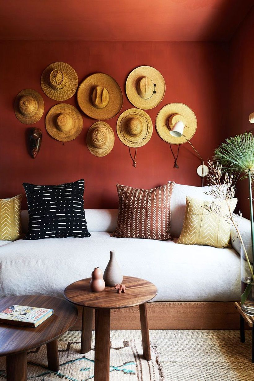 A white sofa in a small family with wooden round coffee tables and hat decoration on the walls