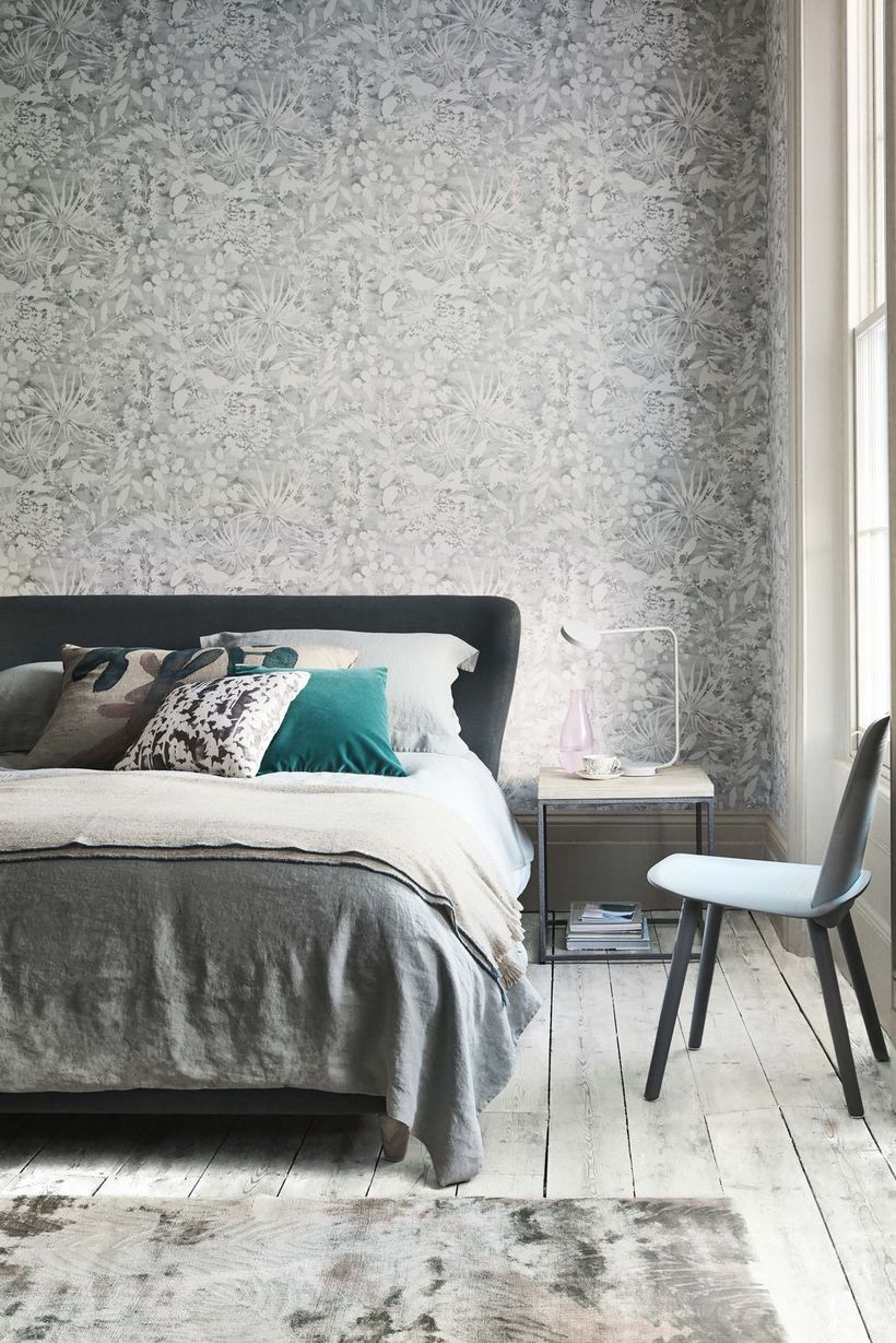 An adorable monochrome bedroom decor ideas with a grey wallpaper with unique pattern, nightstand on beside, and wooden pallet floor