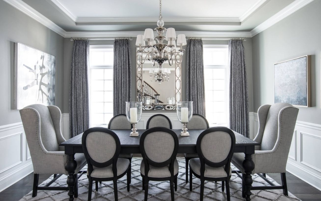An elegant monochrome color dining room decoration with white and grey walls, gray curtains, hanging decorative lights, black and grey furniture