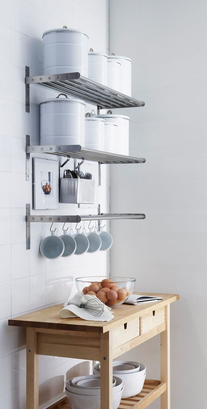Hanging rack that made of metal to put some kitchen appliance and table with drawers and storage on below to store some bowls