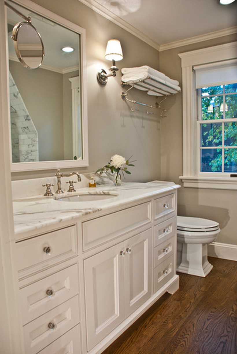 Traditional bathroom decor ideas with a towel hook on the walls, white storage cabinet, a big mirror, and decorative lighting