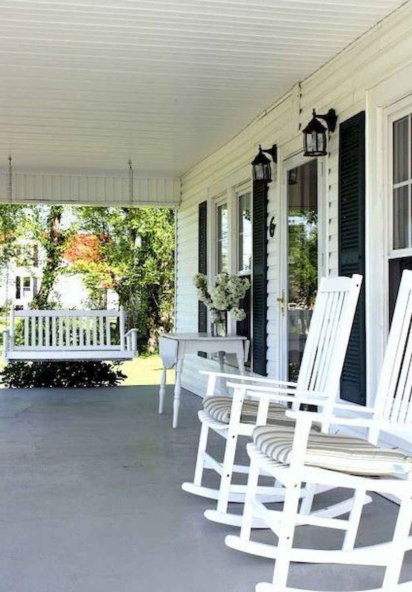 An awesome farmhouse porch furniture with white wooden chairs, a square white wooden table and a hanging white chair