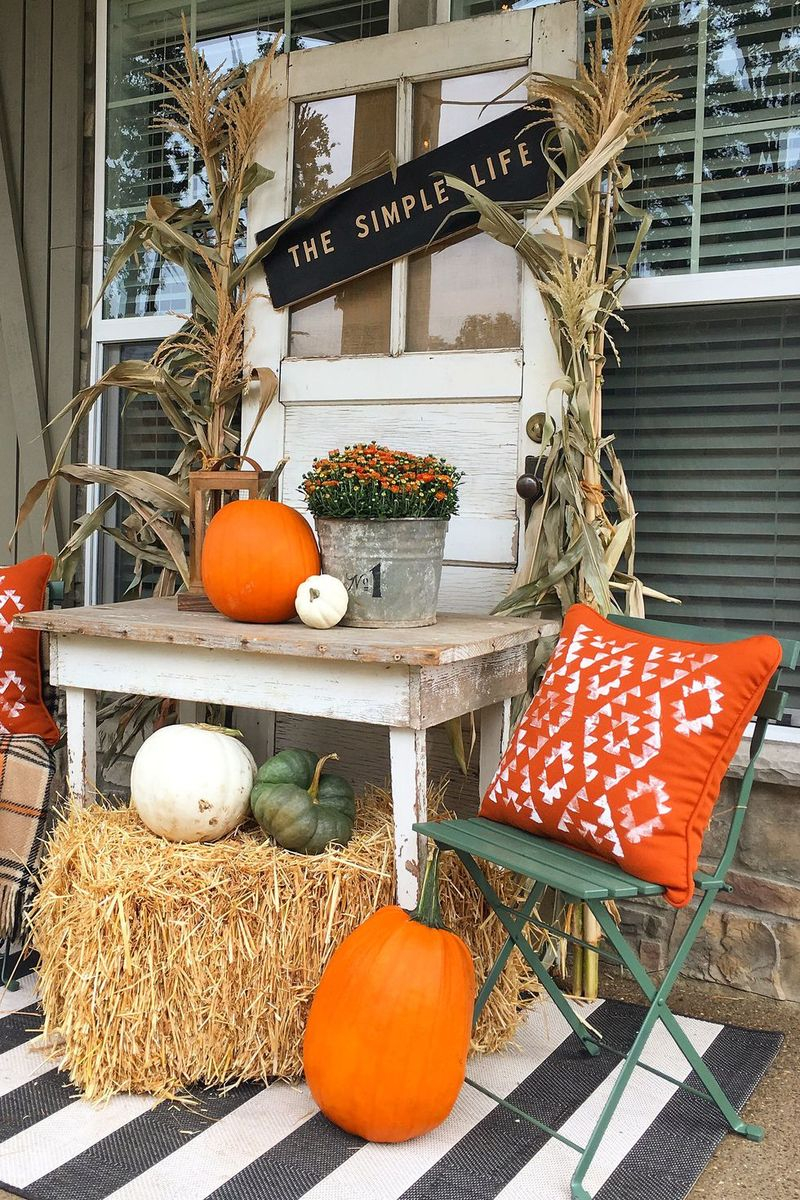 An amazing fall outdoor decoration with corn stalks and hay bales for a fresh fall look
