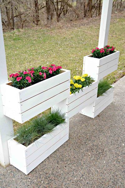 An awesome diy tiered wood flower boxes with red and yellow flowers to beautify your garden