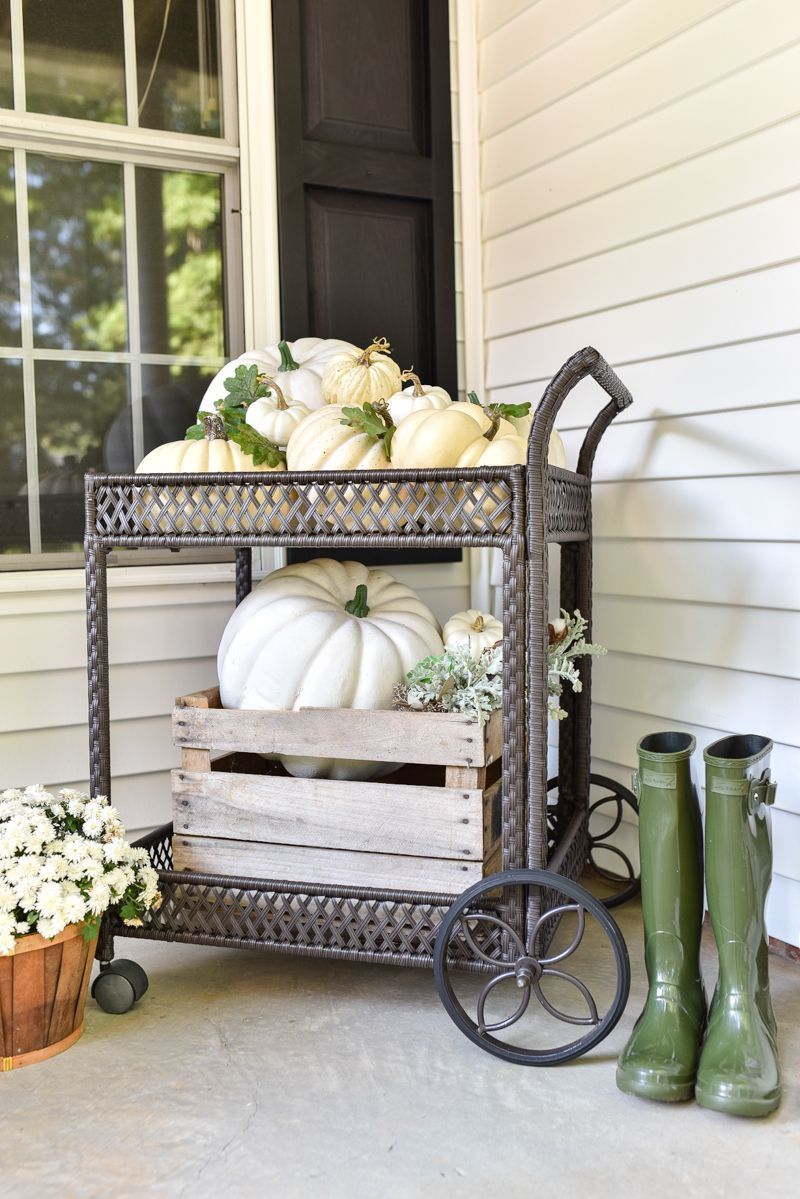 An awesome outdoor bar cart to decorate this fall combine with flowers decoration, boots and pumpkins on each shelf