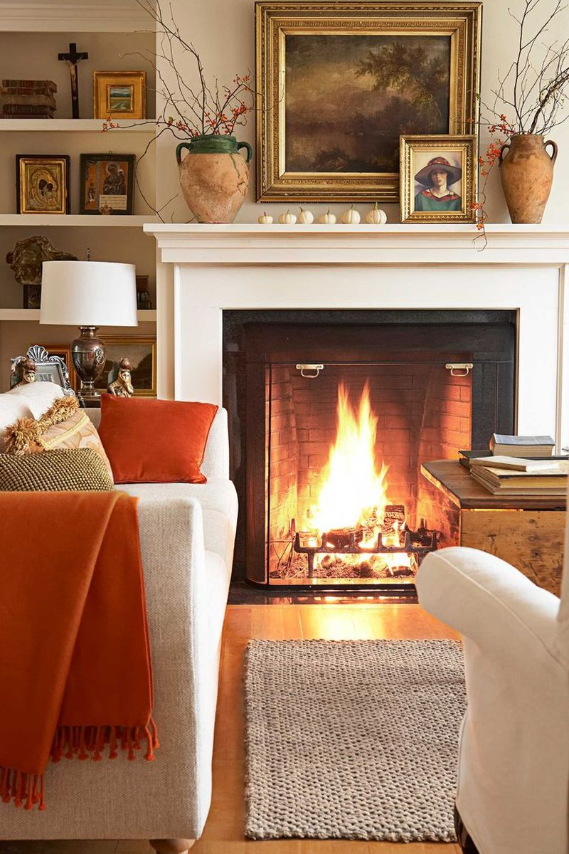 An beautiful fall living room decoration furnished with a nubby cream sofa and white slipcovered chairs, both from crate & barrel