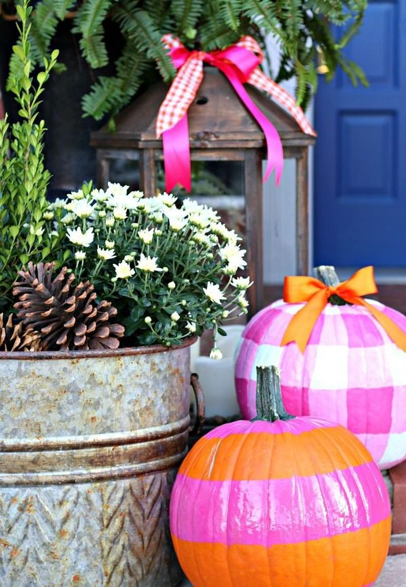 Beautiful fall outdoor decor incorporated hot pink and bright orange in her wreath, pumpkins, and lanterns