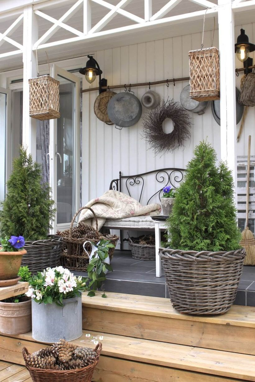 Beautiful farmhouse porch ornament with plants in rattan pots, hanging rattan ornaments, and black lights on the wall