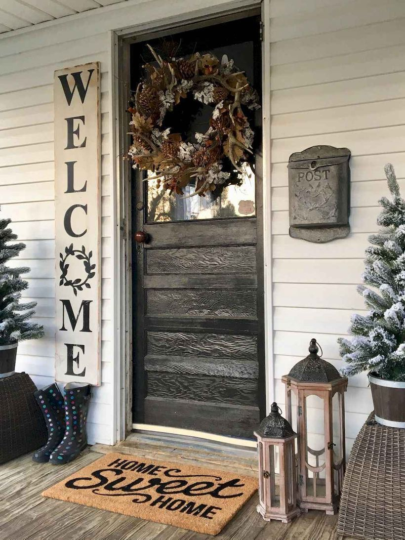 Best farmhouse porch decor ideas with wreath of flowers, twigs, pine fruit, wooden lamps and plants above the basket of rattan