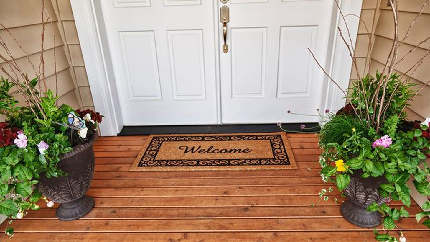 Charming farmhouse porch ornament with patterned black pot plants and a brown carpet to complete your front yard