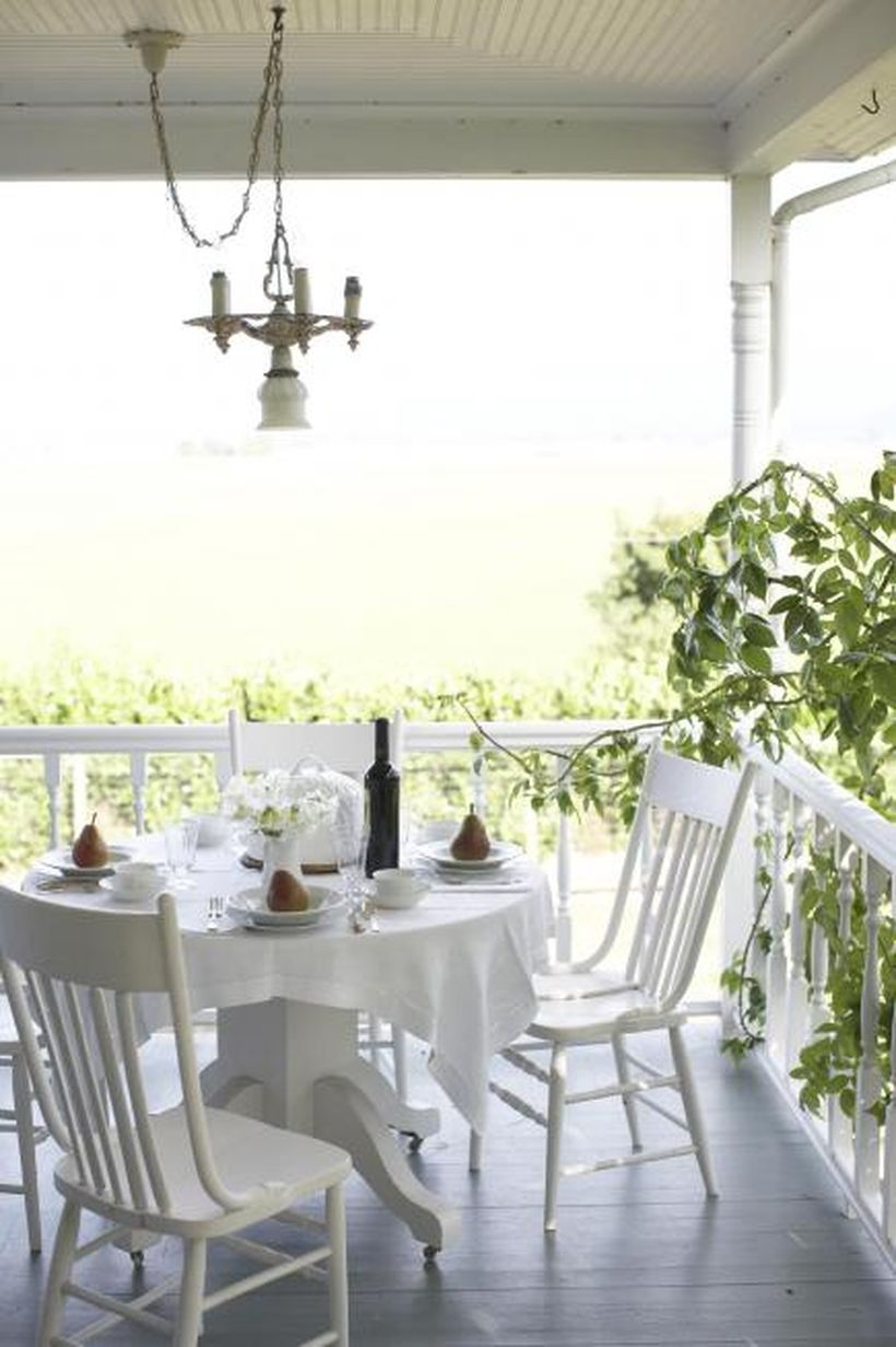Stunning seating ideas with wooden white chairs, a white round table, white tablecloth and a hanging lamp
