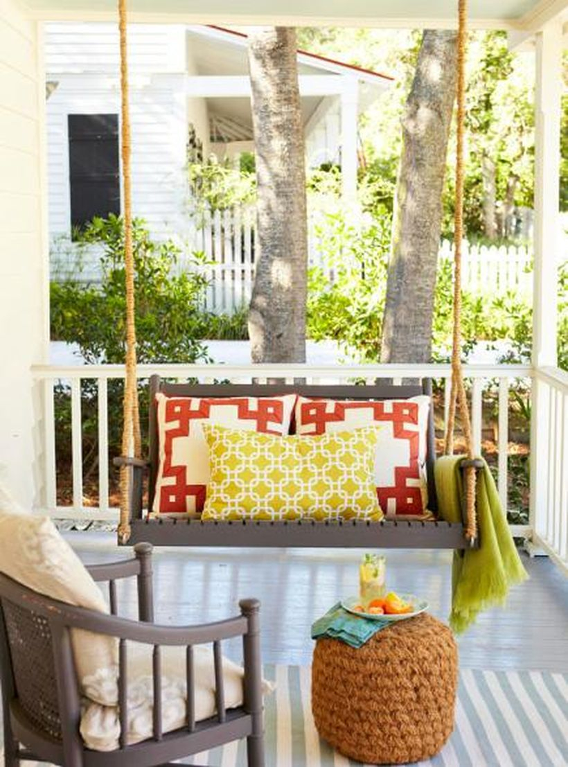 Unique seating ideas with wooden swing chair, red and yellow pillows