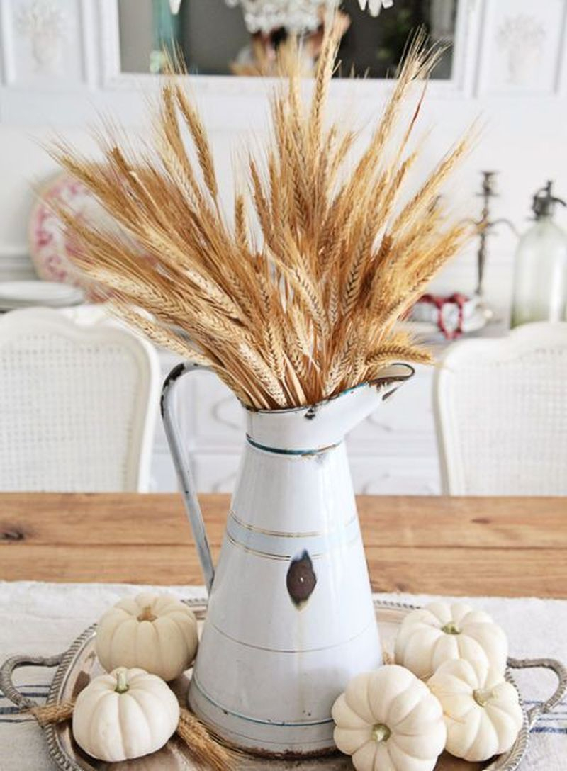 Use an antique pitcher as a vase to hold faux wheat and add neutral-colored pumpkins at the base of the pitcher to complete the look