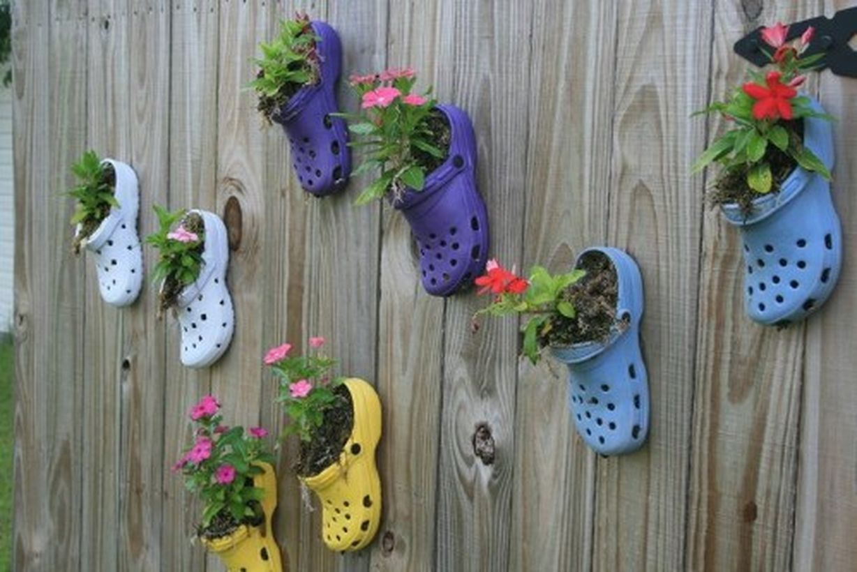 A beautiful plant decoration for garden with those old crocs that you never wear anymore or that the kids have outgrown will make beautiful planters for your fence.