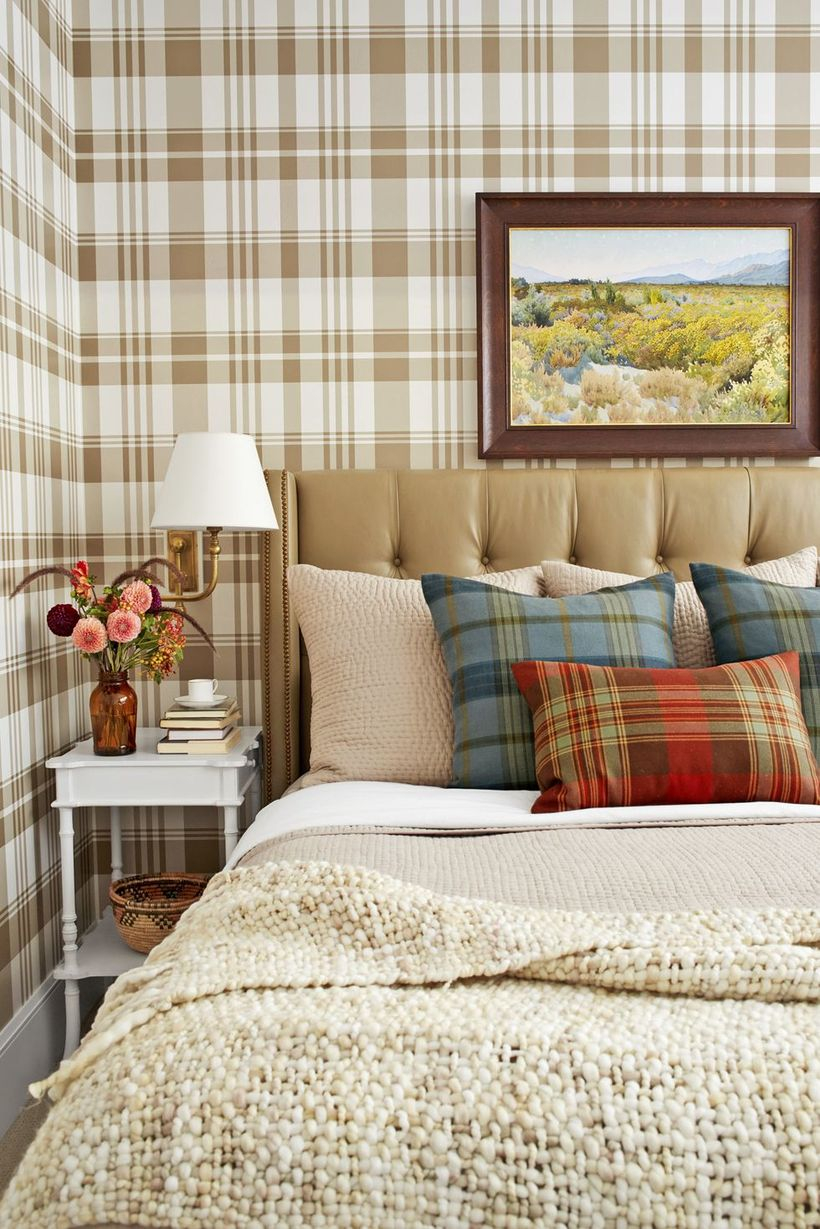A stunning indoor redecoration from summer to fall with incorporate natural elements and earthy wallpaper. piled plaid pillows, blankets, and a cushy headboard.