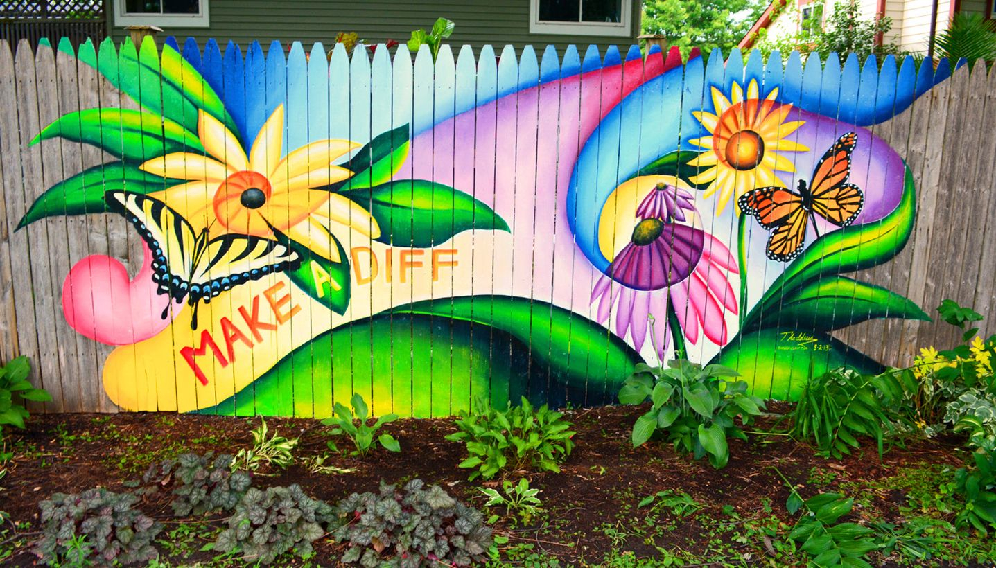 A wonderful painting fence for garden with uplifting colours, pictures, and quotes in the backyard garden.