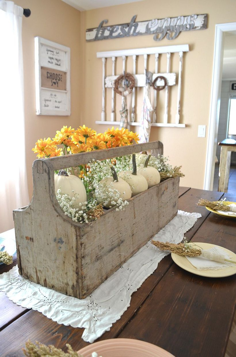 An adorable small white pumpkin ornaments with flowers and square wooden container