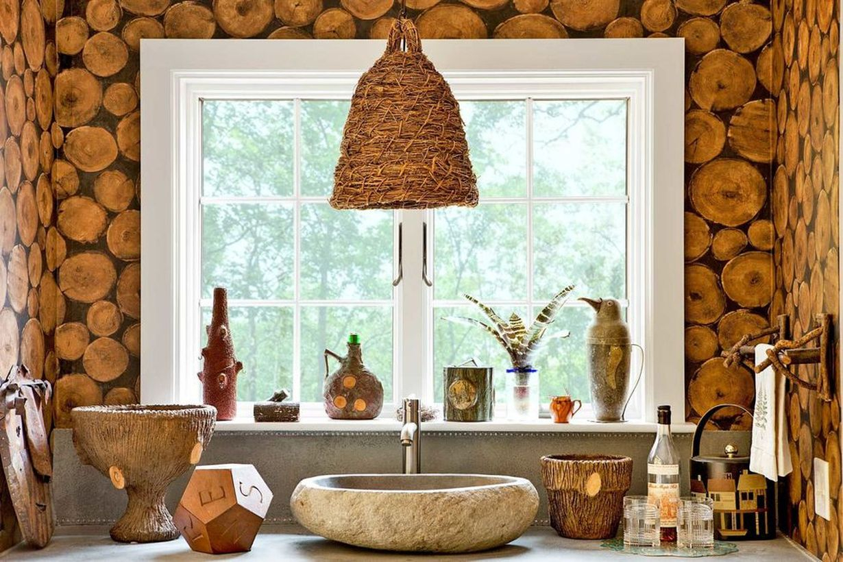 An elegant indoor redecoration from summer to fall with a light made from a vintage skep, river rock sink, small windows and wooden beam wallpaper