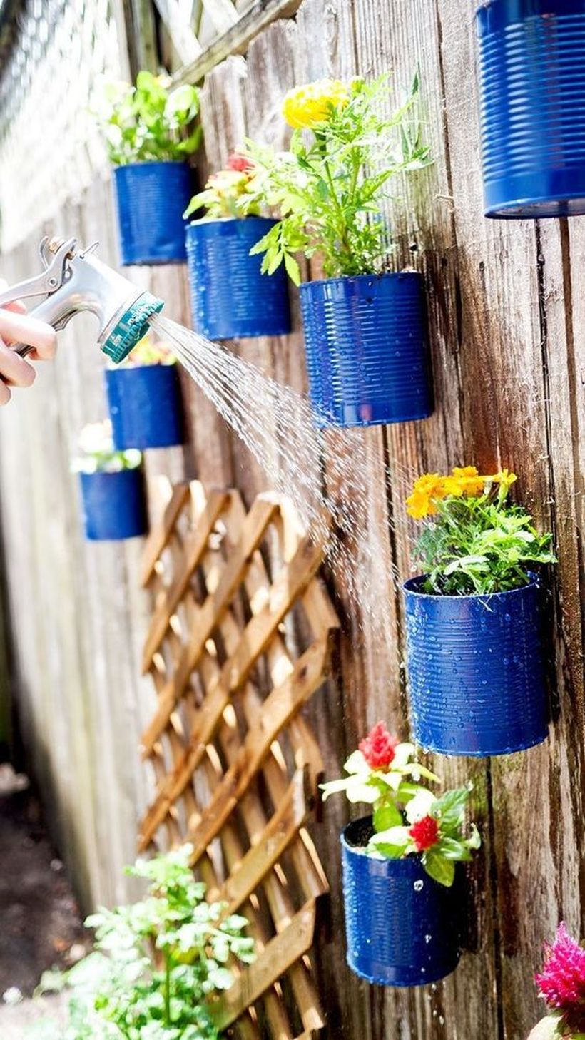 An impressive plant decoration for fence with upcycled tin can planters to decorate your fence with live flowers and it’s a really easy project to complete.