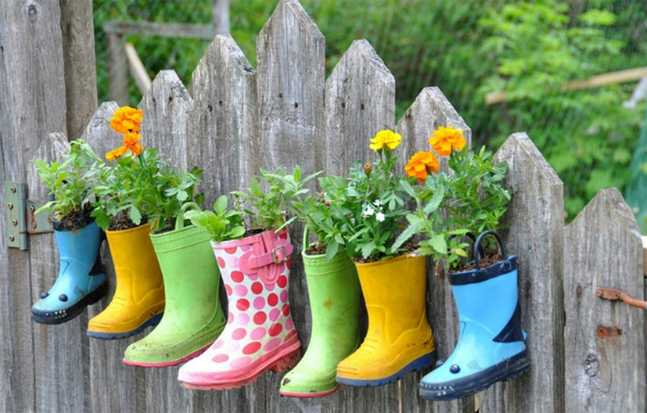 An interesting plant decoration for garden with rain boots make planters absorbed into the fence in the children's garden area stunning.