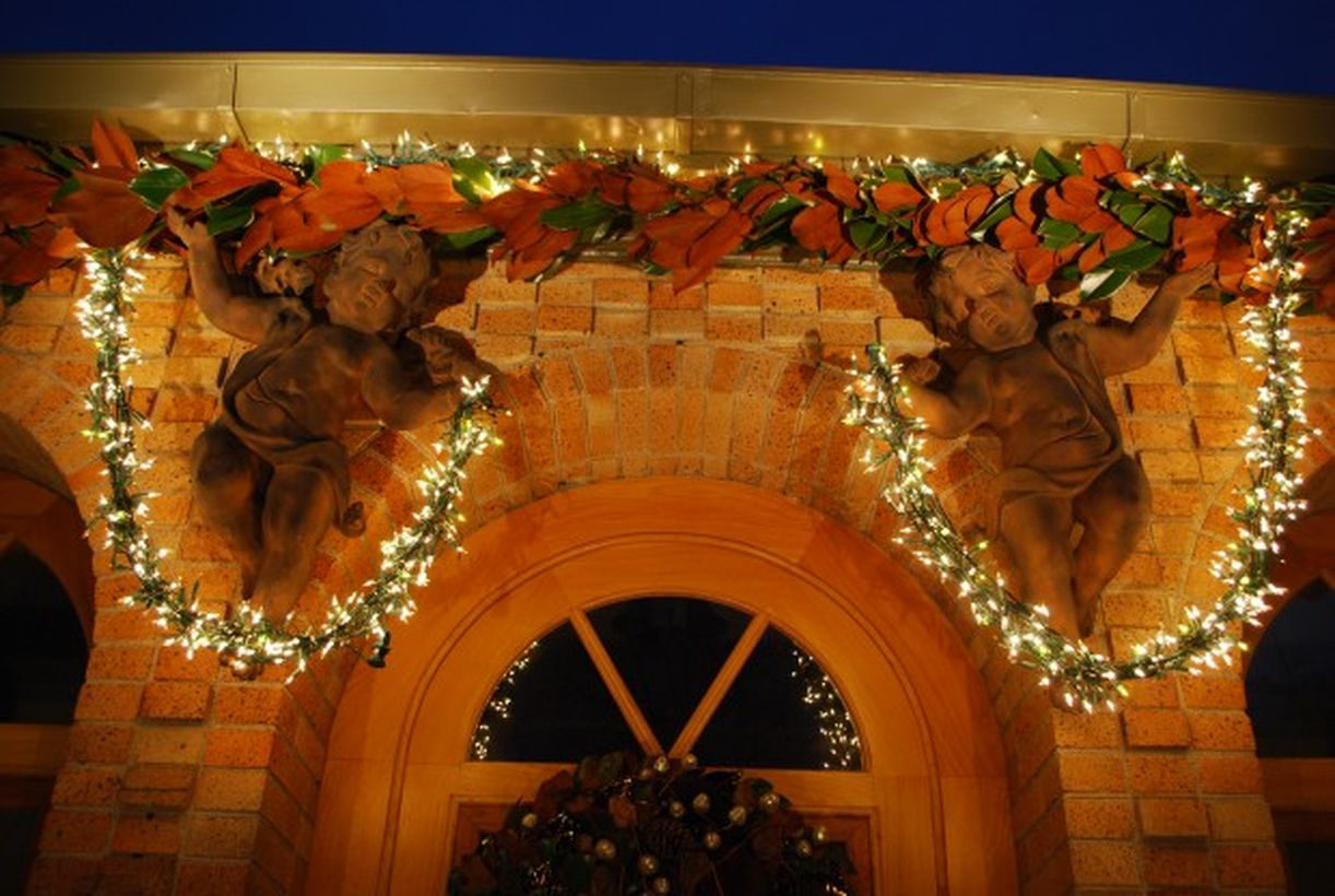 Beautiful dry leaves garlands with string lamps and fairy sculptures for decoration above the door of the house