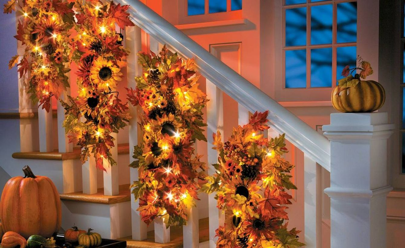 Pretty dry leaves garlands with sunflowers and small lamps to make your stairs good
