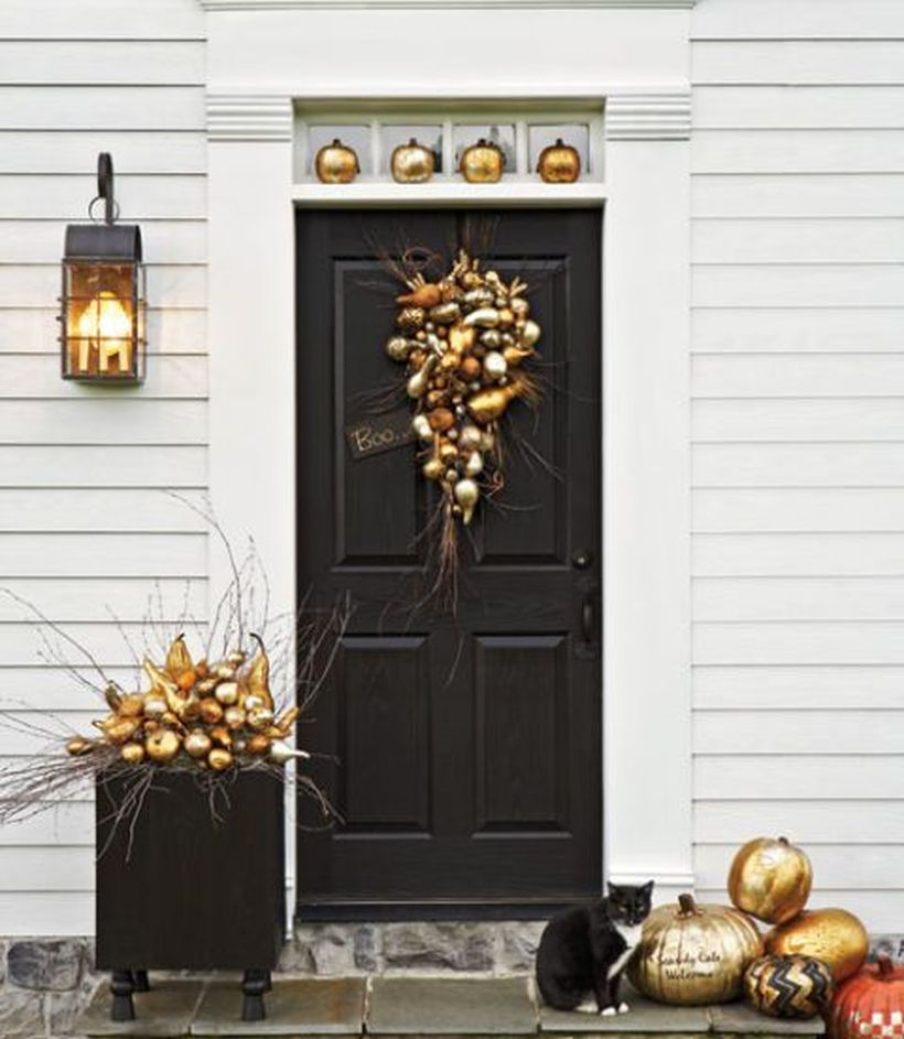 Cozy fall porch decorating ideas with gold pumpkin wreath, and gold pumpkin arrangement