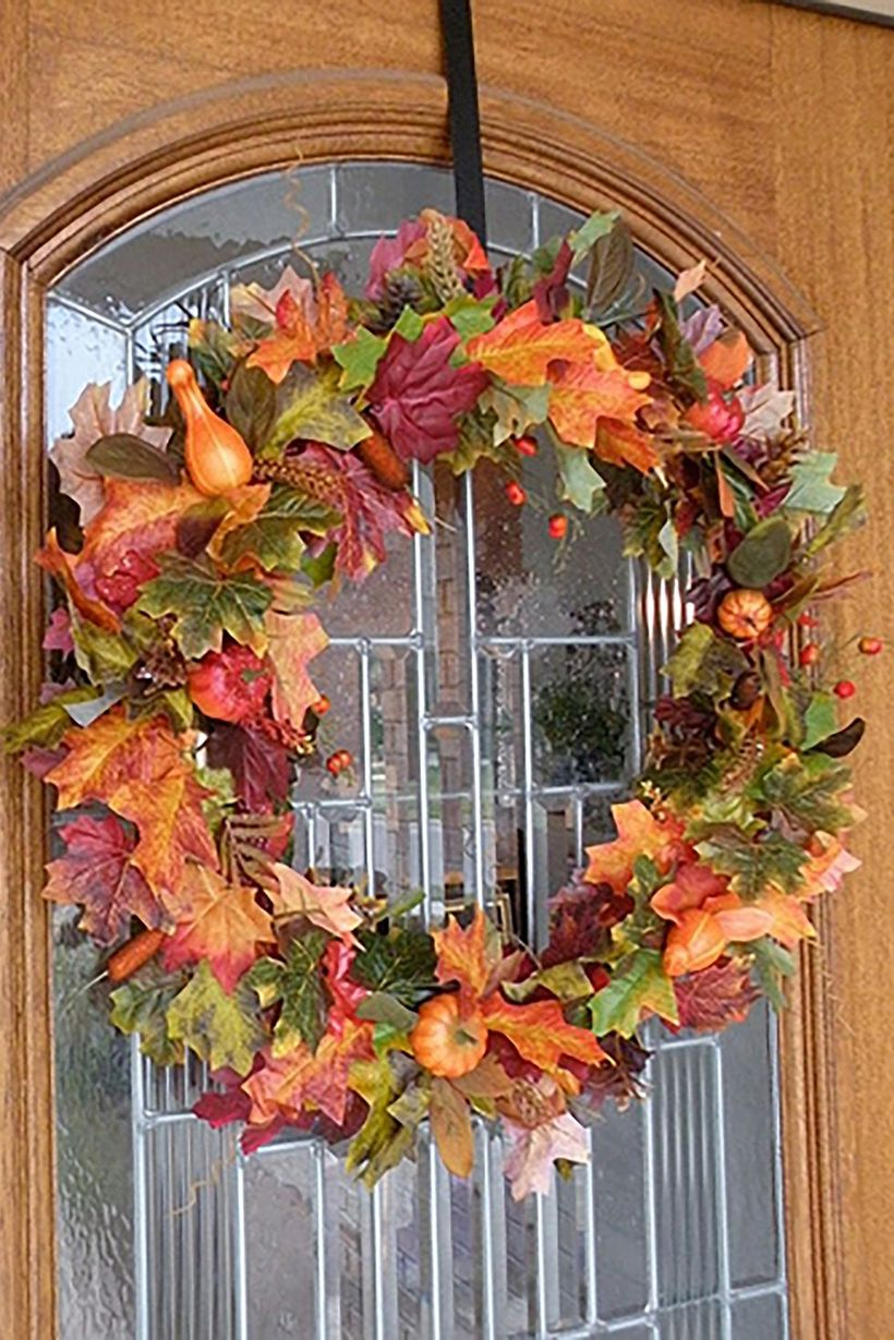 Creative dry leaves garlands with small orange pumpkins for door decoration