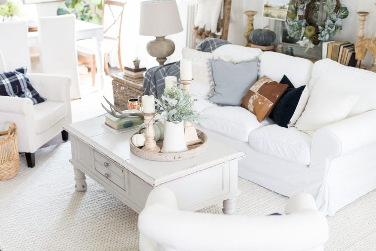 Stunning white living room with white sofas, white rug, and decoration white pumpkin on table coffee you must try