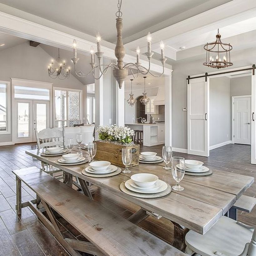 A beautiful rustic chandelier for dining room with 5-light chandelier in antique, wooden table, wooden chairs and big windows.