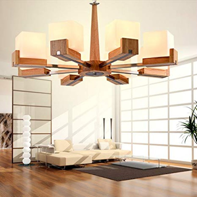 A comfortable rustic chandelier for living room with nostalgic chandelier, wooden vinyl floor, letter l white sofa, house plant and a black carpet.