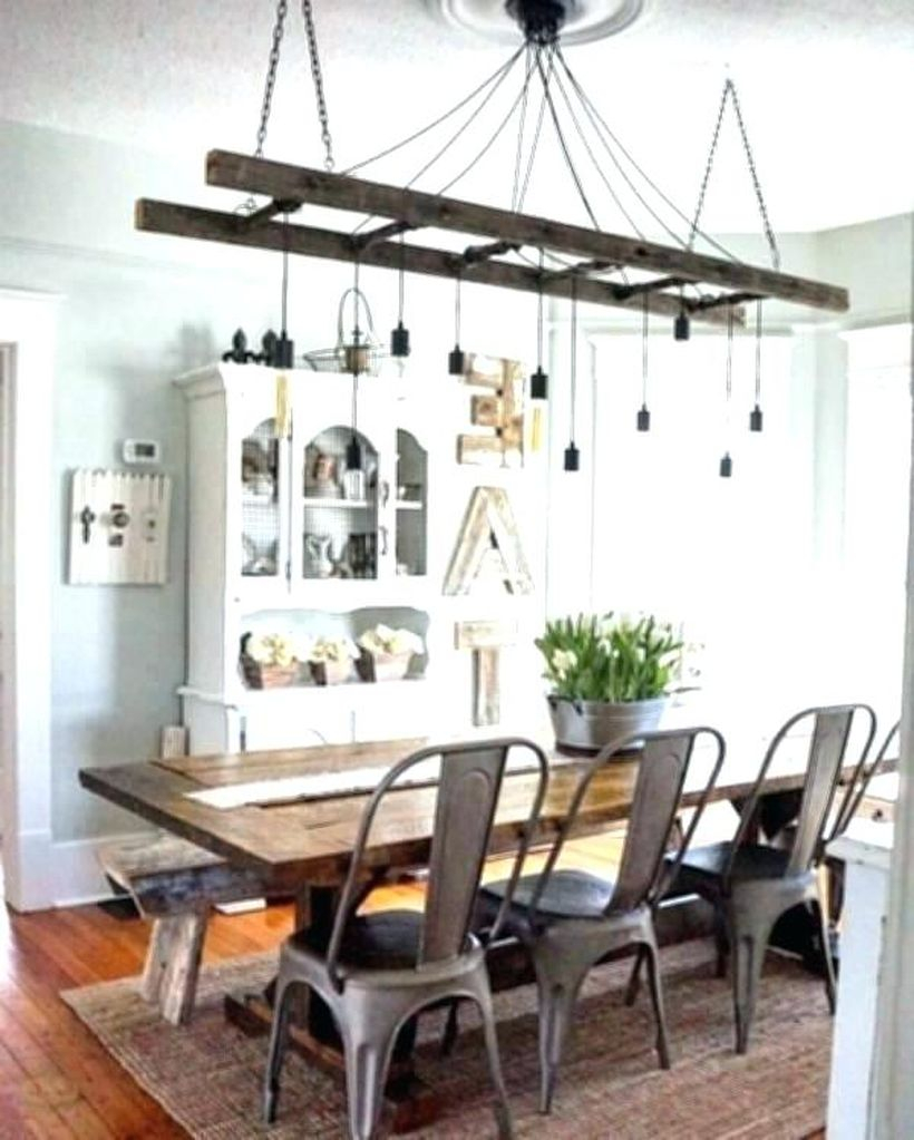 A wonderful rustic chandelier for dining room with track chandelier, big wooden table, iron chairs, white closet, small carpet and large windows.