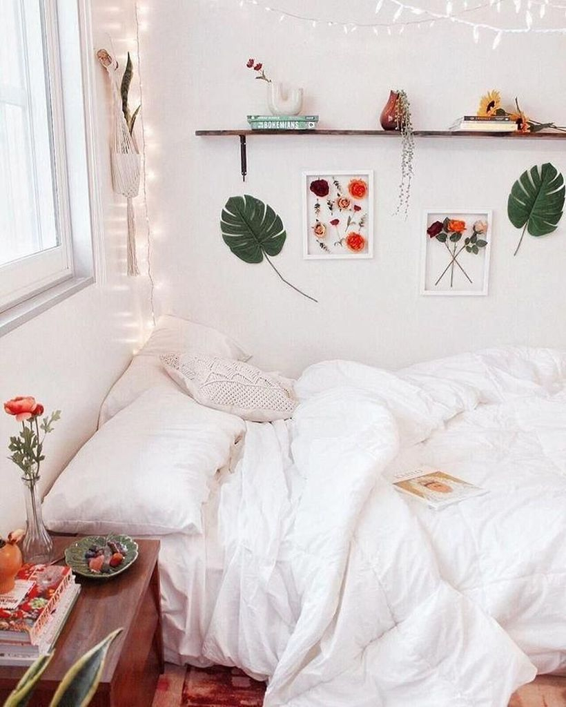 An amazing girls room decoration with white bed, white pillow, white blanket, wooden rack on the wall and hanging string lamps