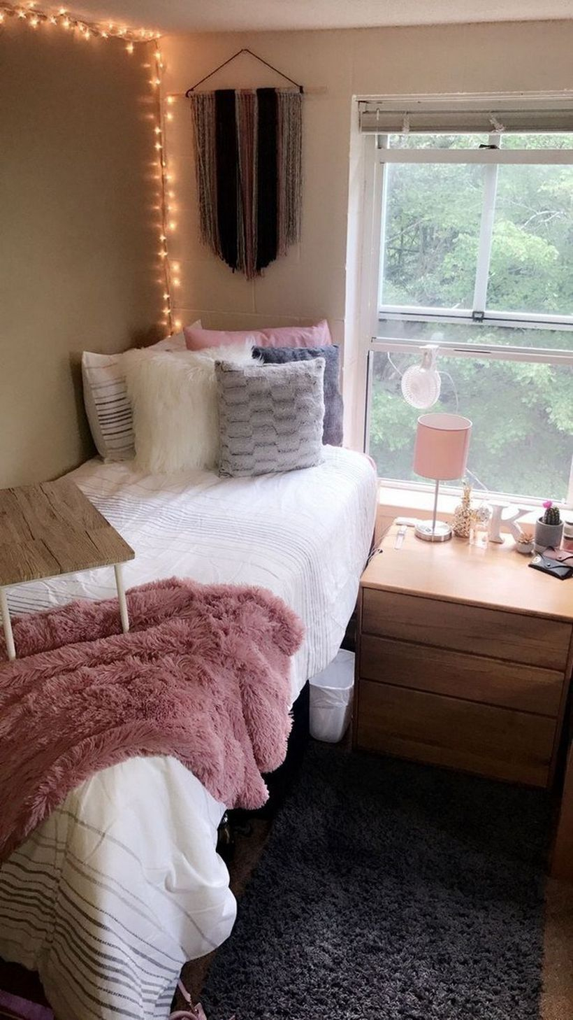An awesome girls room decoration with white blanket, colorful pillow cover, small pink fur blanket, small table on the mattress, wooden cabinet storage, string lamps to look beautiful