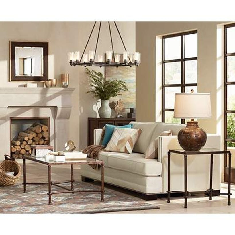 An adorable rustic chandelier for living room with wide olde bronze wagon wheel chandelier, grey sofa, iron table, small carpet and big window.