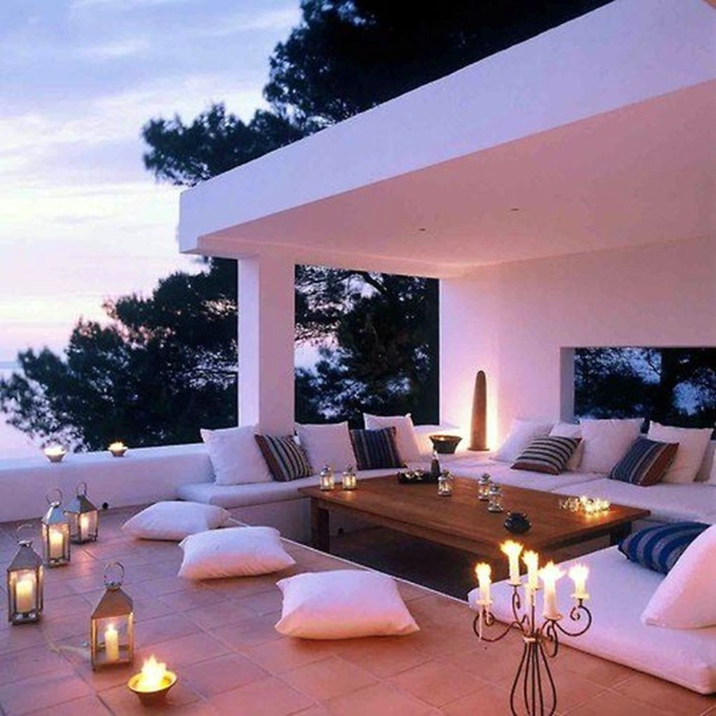 An amazing small rooftop lighting with candle lights combined white sofa and wooden table to perfect your rooftop design