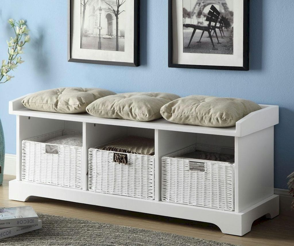 An elegant white wooden storage bench with basket below it and cushion to perfect your entryway decor