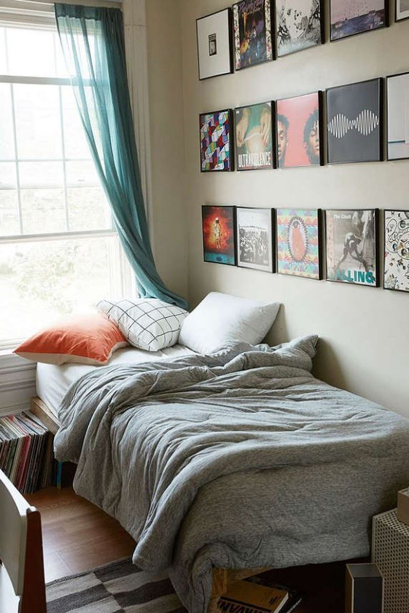 Best boys room decoration with white mattresses, gray blankets, white and orange pillows, a window, blue curtain and decorative paintings on the wall