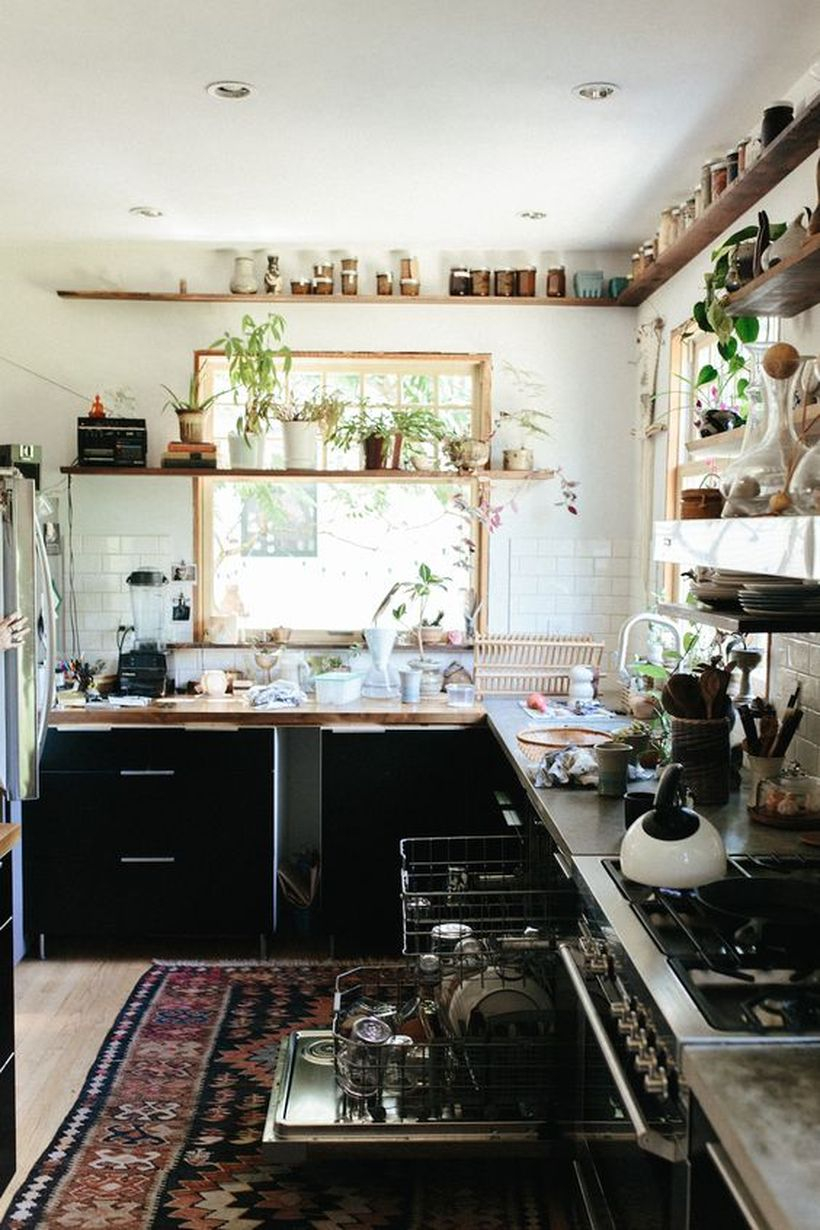 Boho kitchen decor with patterned carpets in black, storage cabinets, and wooden rack shelves to make it look cool