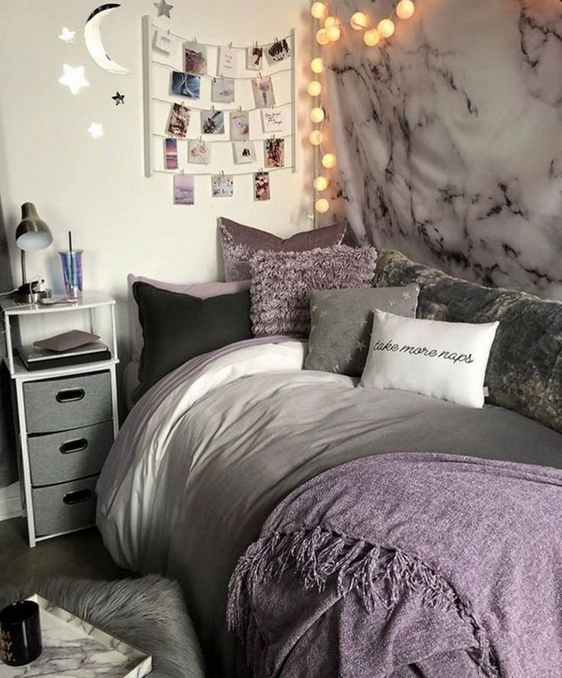 Girls room decor with white gray mattress, purple blanket combined with colorful pillows, decorative fabric walls and round string lamps on the wall