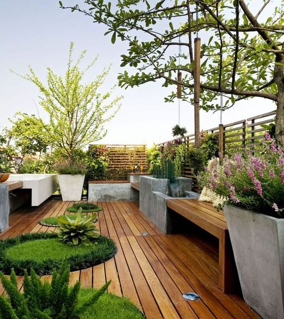 Mesmerizing small rooftop design with wooden seating combined with wooden floor and plants around it to beautify your rooftop garden